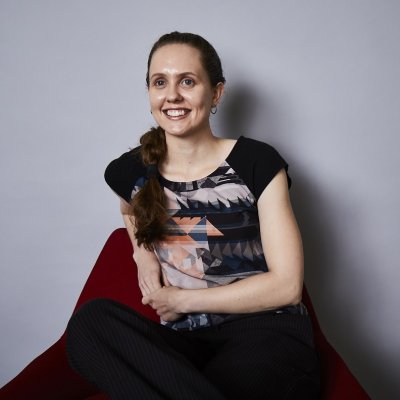 Post graduate student Alicia Kirk smiles at the camera, while sitting on a beanbag.